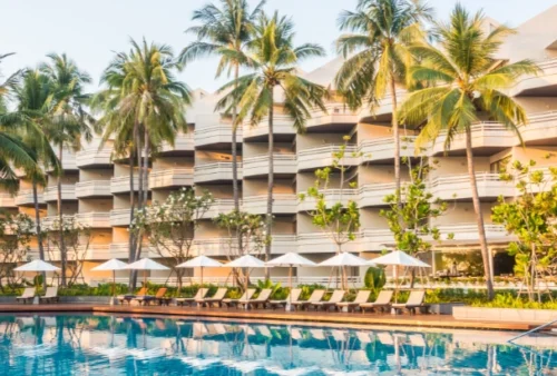 Foto: lifeforstock no Freepik | fachada de hotel com palmeiras, piscina e cadeiras de descanso | Marketing digital para hotelaria