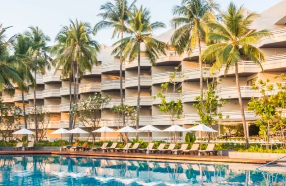 Foto: lifeforstock no Freepik | fachada de hotel com palmeiras, piscina e cadeiras de descanso | Marketing digital para hotelaria